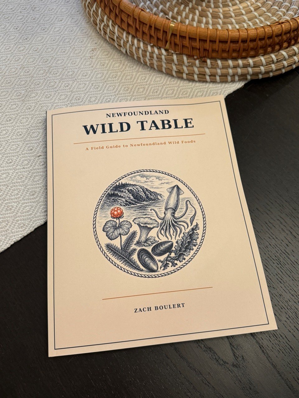 Complete front cover of Newfoundland Wild Table on a dark table
