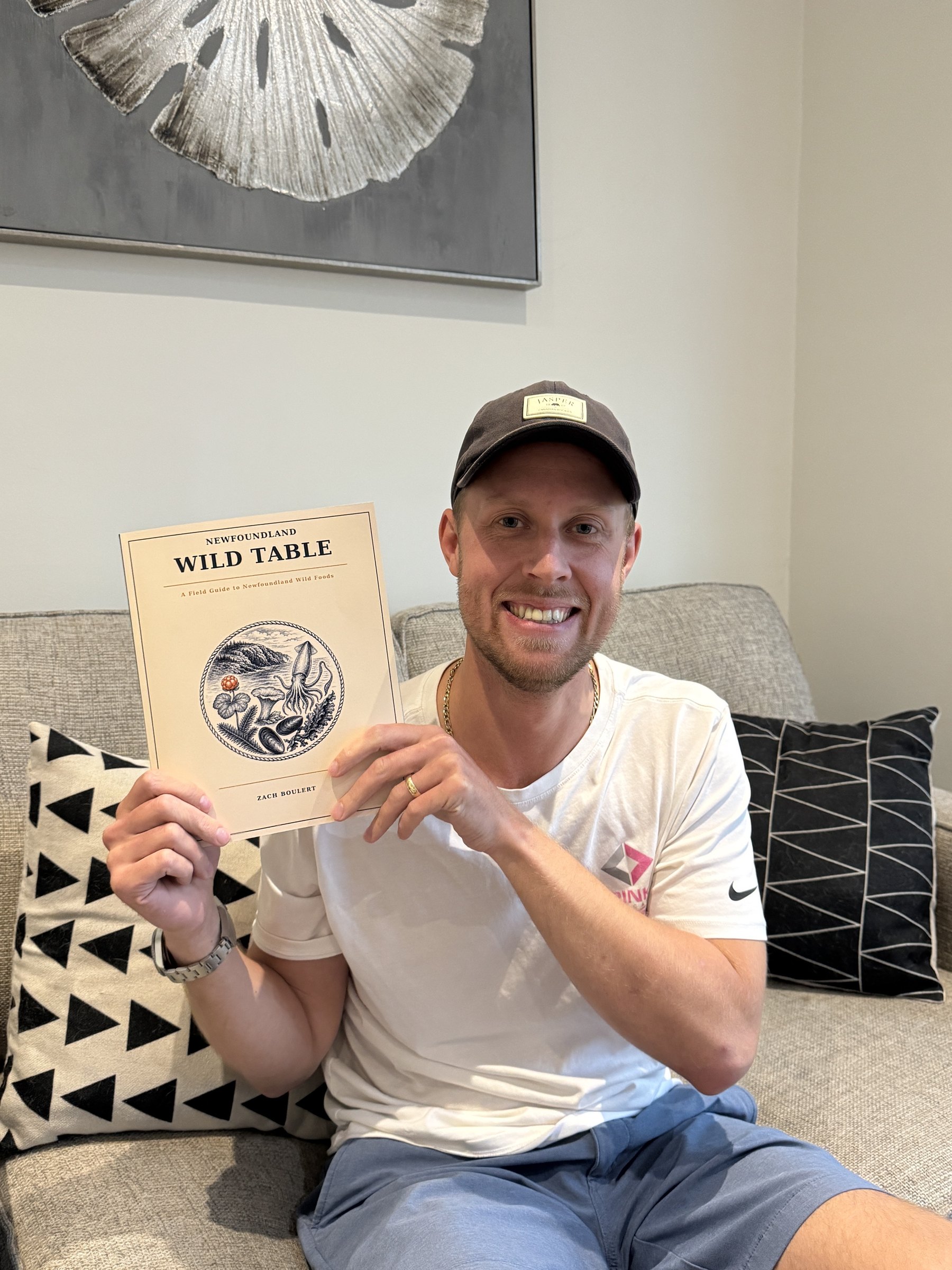 Zach Boulert smiling and holding a copy of Newfoundland Wild Table